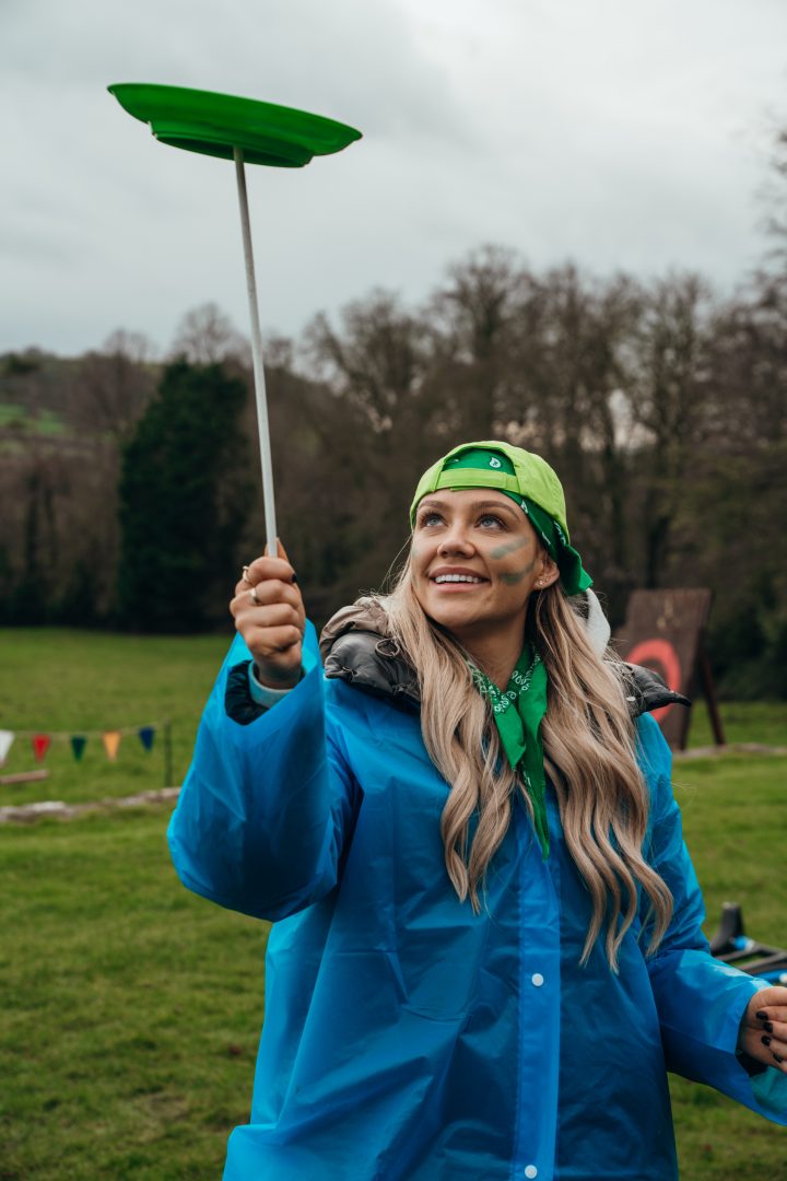 Woman balancing a plate on a stick during an outdoor event