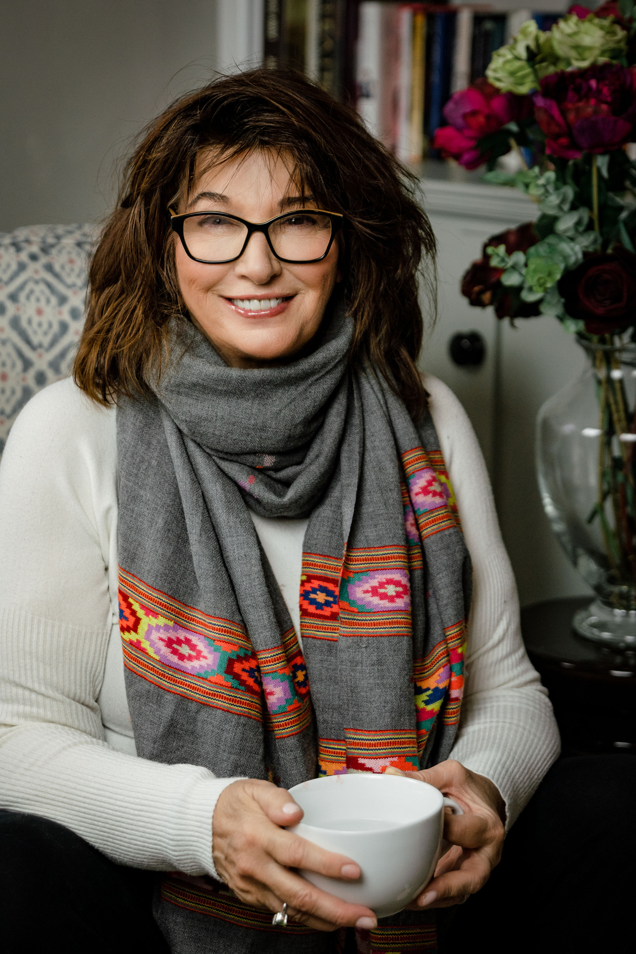 Cozy portrait of a woman holding a cup of tea and smiling